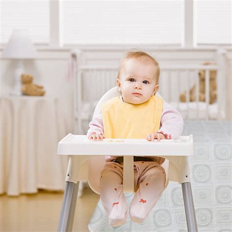 Bambino sorridente seduto in un seggiolone portatile durante un pasto in famiglia
