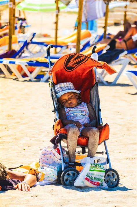 Bambino in passeggino su spiaggia