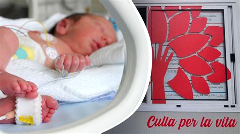 Genitore che appoggia delicatamente il neonato nella culla