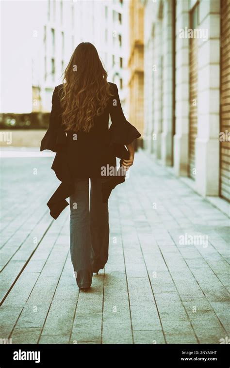 Donna che cammina in strada indossando stivaletti e un abito midi elegante
