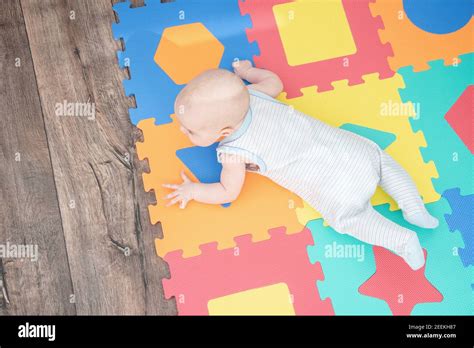 Bambino che assembla un puzzle colorato su un tappeto