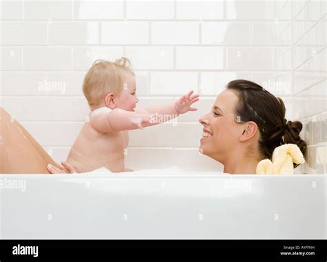 genitore che sostiene un bambino scivoloso in vasca