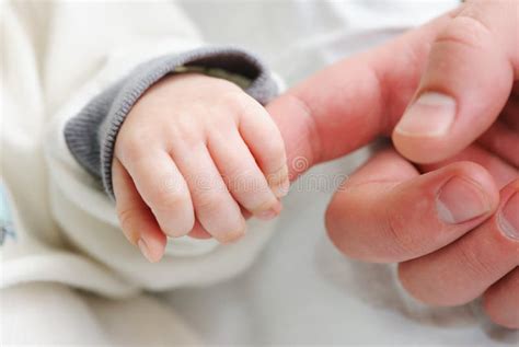 Mani di genitore che vestono un neonato