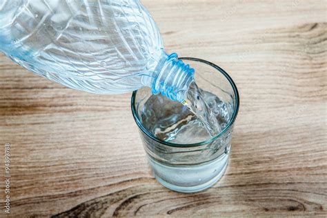 Bambino che versa acqua in un bicchiere di vetro in un contesto scolastico Montessori