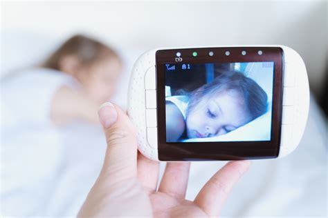 Un genitore che osserva il proprio bambino dormire tramite un baby monitor