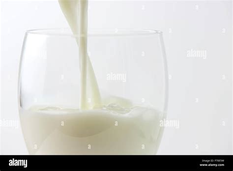 Dettaglio di un bicchiere di latte di mandorla versato in un contesto luminoso