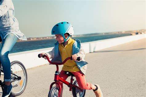 Bambino che indossa il casco mentre pedala su una bici Avengers in un vialetto sicuro