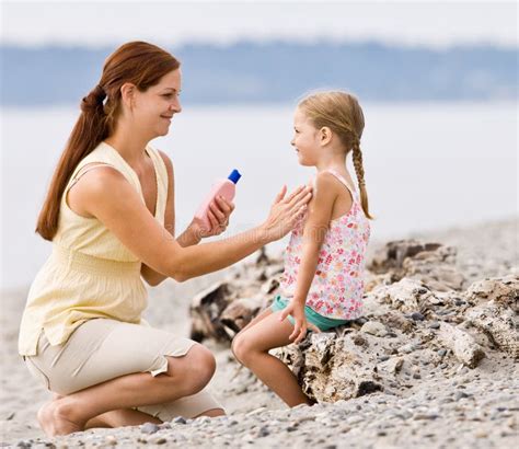 Famiglia che applica crema solare ai bambini in spiaggia
