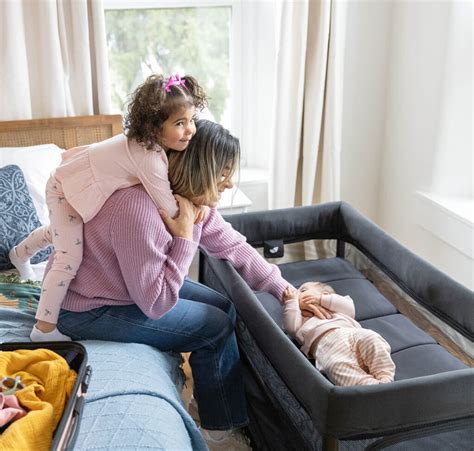 Famiglia che prepara un lettino da viaggio in un ambiente accogliente
