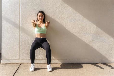 Persona che esegue un wall sit contro un muro
