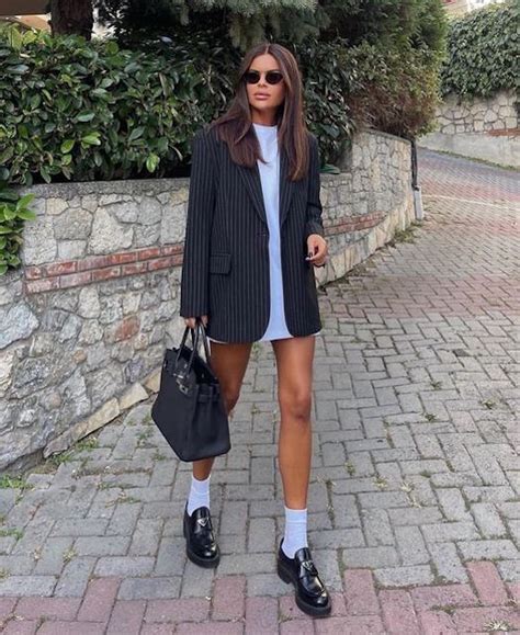outfit con minigonna trapuntata scura e mocassini bicolore bianchi e neri