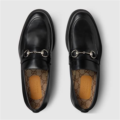 dettaglio di mocassini con morsetto tipo Gucci horsebit e calze colorate