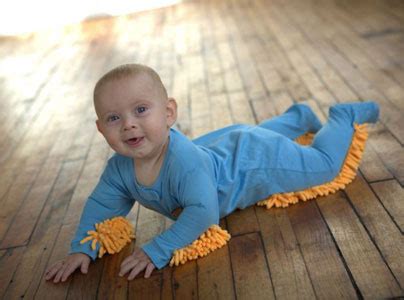 Bambino che gattona con la tutina Baby Mop sul pavimento pulito