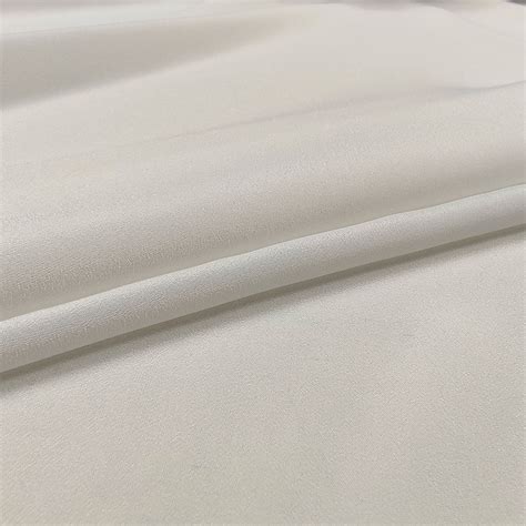 Dettaglio di tessuto crêpe bianco su una tuta sartoriale