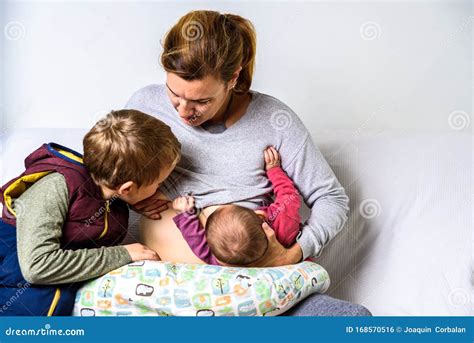 Mamma che allatta due bambini in tandem
