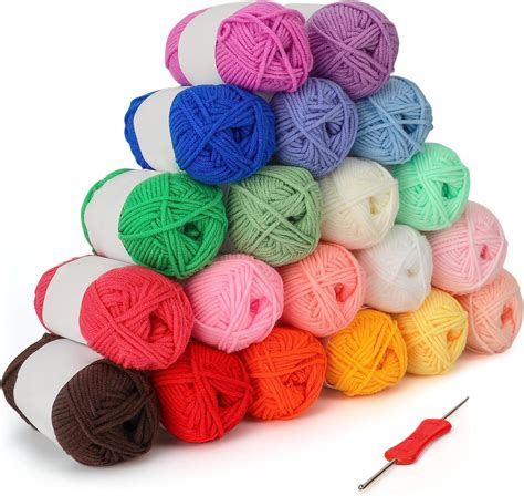 gomitoli di cotone colorato e uncinetti di diverse dimensioni su un tavolo da lavoro