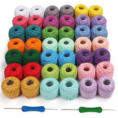 set di filati in cotone di alta qualità disposti accanto a un uncinetto e una bambola amigurumi finita