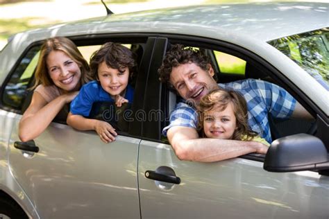 Famiglia sorridente che sale in auto con seggiolini