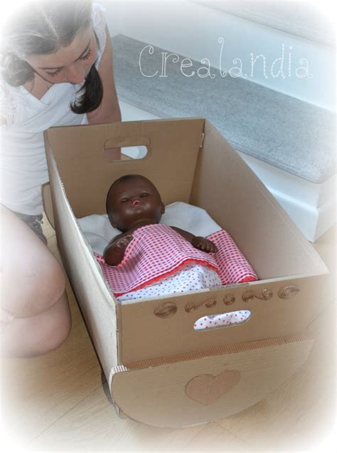 Bambino che gioca con una culla di cartone