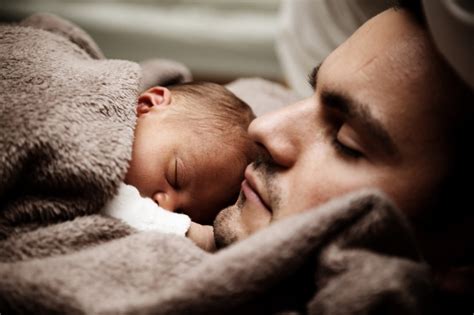Genitore che osserva il proprio neonato dormire
