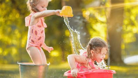 Bambini che giocano al Giro d'Ali con giochi d'acqua e un tappeto elastico