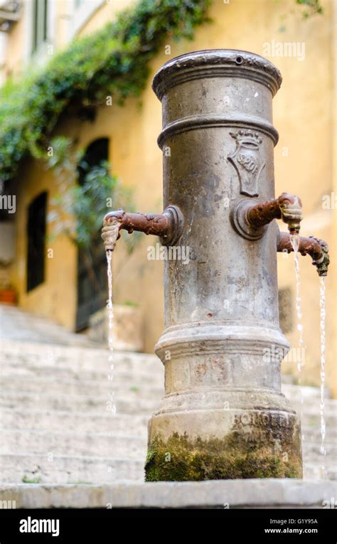 fotografia di un tipico nasone romano in una piazza di Roma