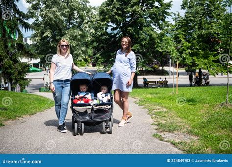 Famiglia che passeggia con un passeggino Hartan in un parco
