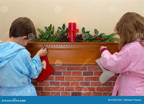 Children hanging stockings by the fireplace