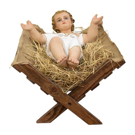 dettaglio ravvicinato di una statuina di Gesù Bambino in legno intagliato con culla