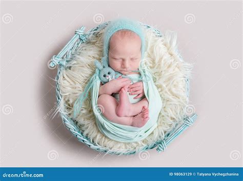 Neonato che dorme serenamente avvolto in una mussola