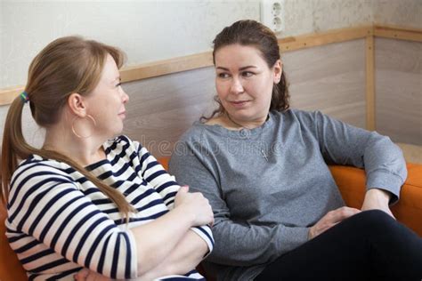 Due donne che si parlano in un contesto di gruppo, una delle due è incinta