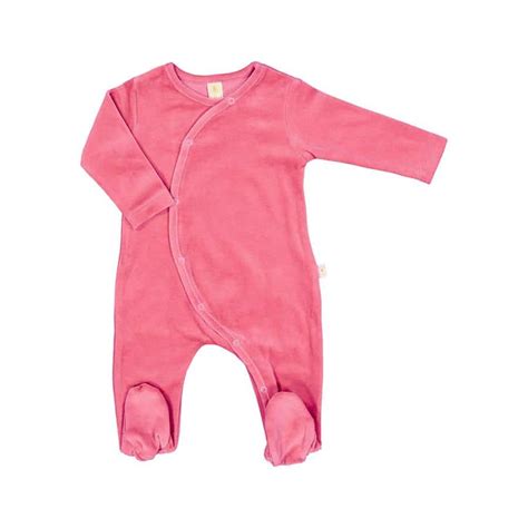neonato che dorme serenamente vestito con una tutina in cotone biologico