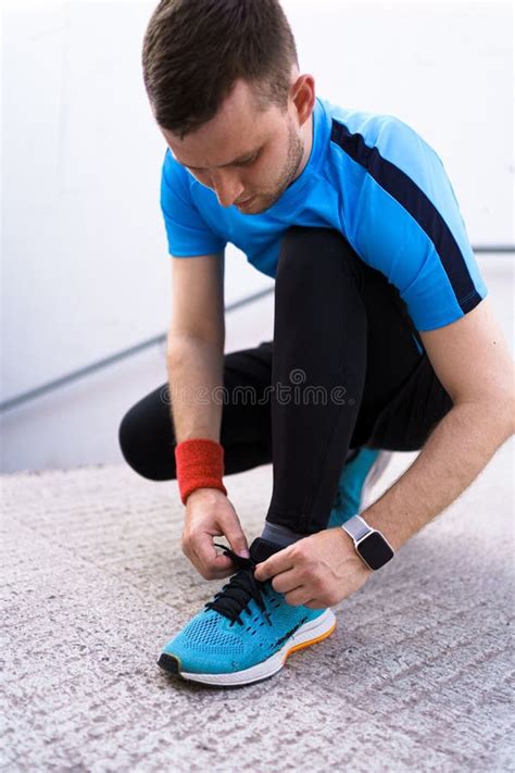 Bambino con tuta sportiva che si allaccia le scarpe