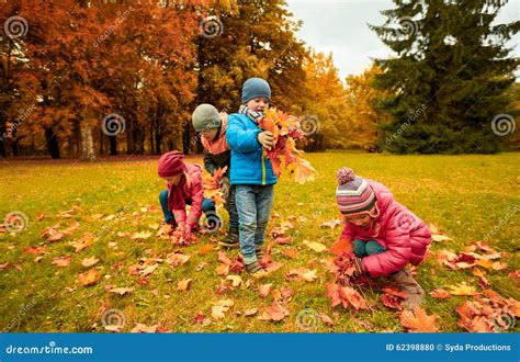 Bambini che raccolgono foglie in un parco autunnale