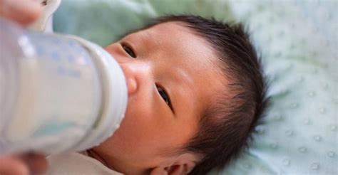 Bambino che beve dal biberon Avent