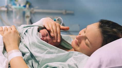 Un'ostetrica che guida amorevolmente una madre durante le fasi del travaglio in un ambiente ospedaliero umanizzato.