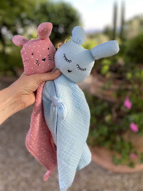 Un neonato che abbraccia un doudou a forma di coniglietto