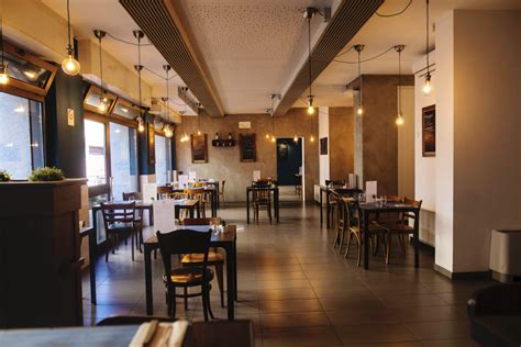 Veduta d'insieme di una sala moderna in pizzeria con luci soffuse e design ricercato