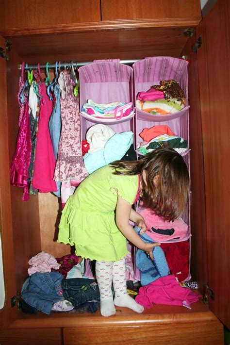 Bambina che sceglie tra diverse paia di scarpe nel suo guardaroba