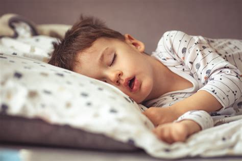 Un bambino che dorme sereno con intorno pianeti e stelle stilizzate