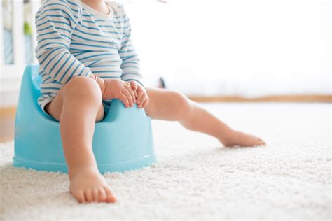 Bambino che prova ad usare il vasino con pannolino a mutandina