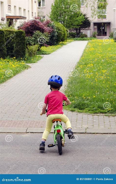Bambino che pedala su un triciclo classico