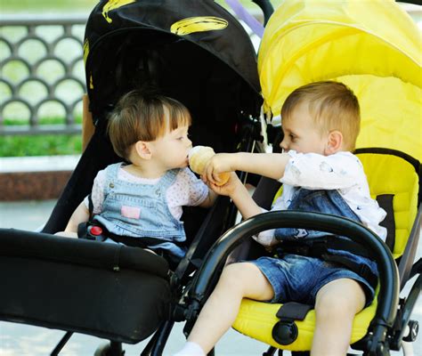 Genitori con bambini sorridenti su passeggini Elefantino
