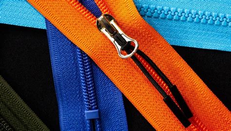 Dettaglio tecnologico di una cerniera idrorepellente e comparti interni organizzati di una borsa da viaggio per genitori