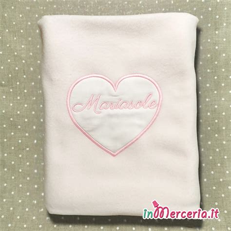 Dettaglio di un ricamo a forma di cuore su una copertina in pile per neonato