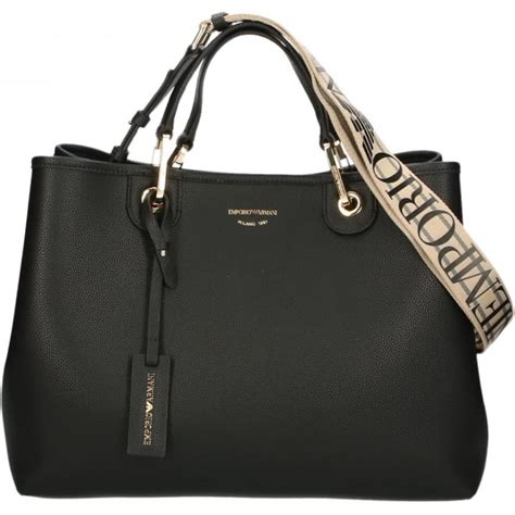 Dettaglio placca logo Armani Junior su borsa fasciatoio nera