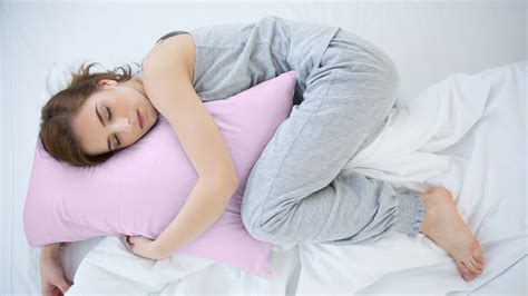 Donna incinta che dorme con cuscino tra le gambe