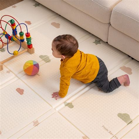 Bambino gattona sul tappeto giochi