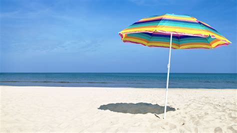 famiglia con neonato sotto un ombrellone in spiaggia
