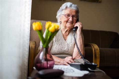 Donna anziana che parla al telefono in un ambiente domestico